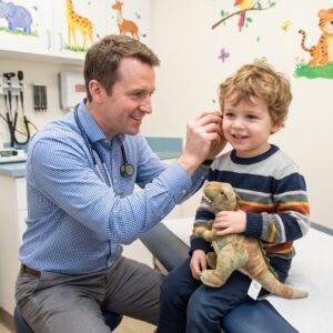 Male Pediatrician Treating Young Boy