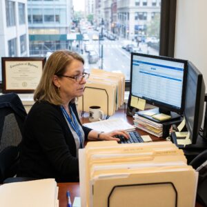 Medical Credentialing Specialist Analyzing Data at Desk
