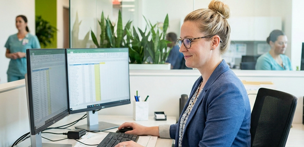 cpcs-medical-credentialing-specialist-at-desk | Medwave Billing and Credentialing Medical Credentialing Specialist Analyzing Highlighted Claims Data in a Spreadsheet at a Healthcare Office Desk